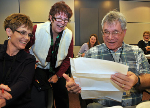 Carla Snyder, left, Darlene Muscanell and Mike Norris get a laugh out of one the letters to Santa during a Letters to Santa work session.